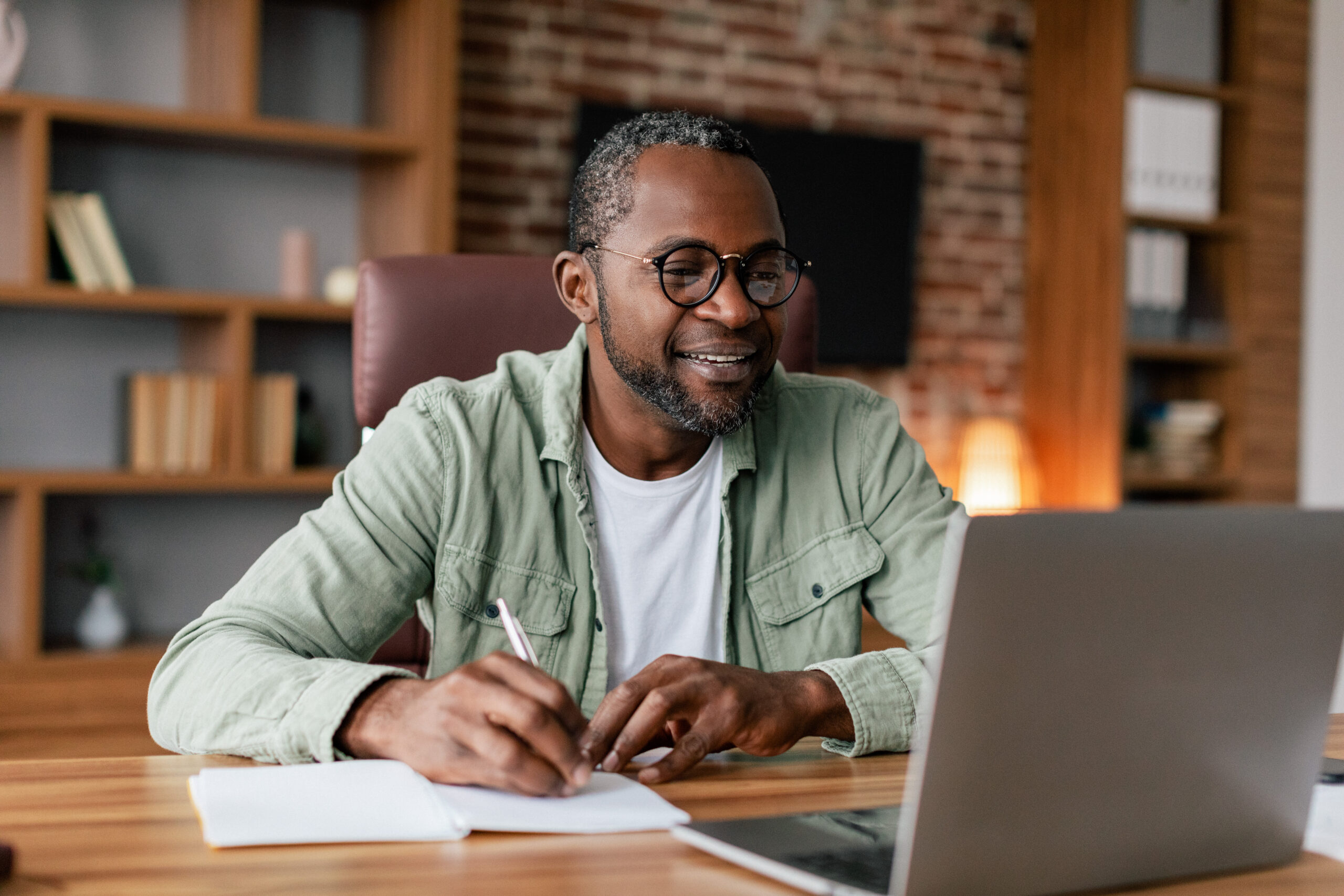 Smiling Middle Aged African American Male in Glasses on Laptop