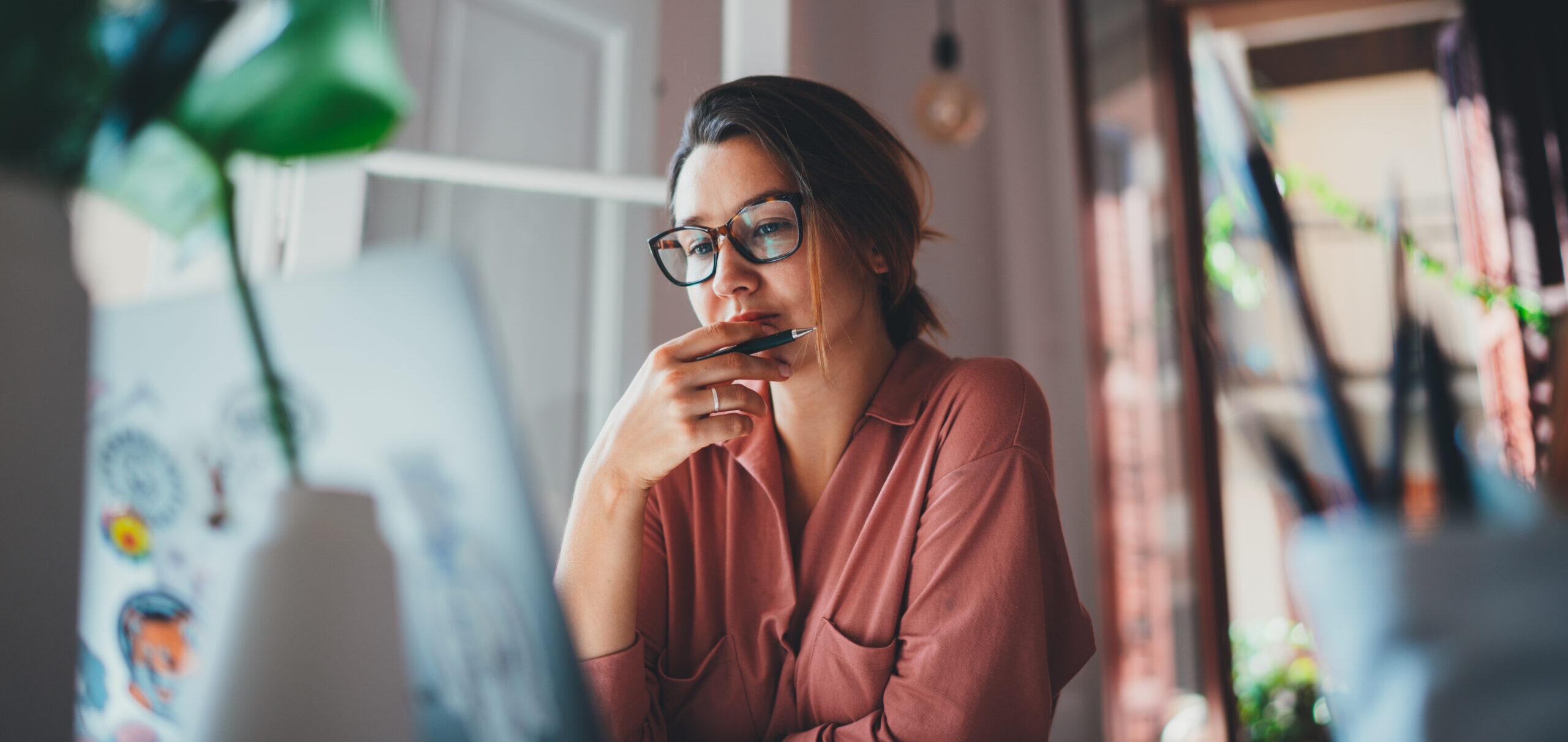 Young Businesswoman Looking at Laptop Deep in Thought