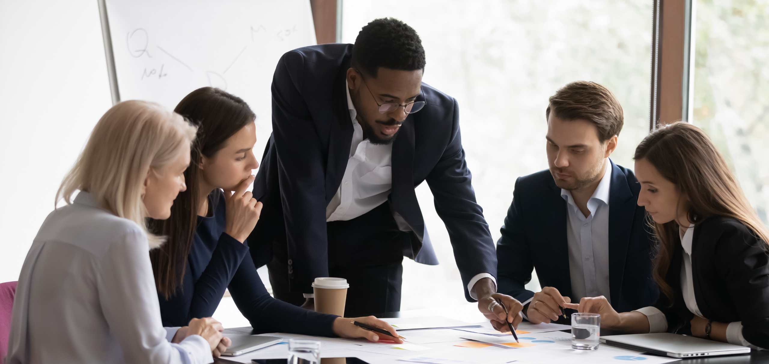 Businesspeople looking at documents on conference room table