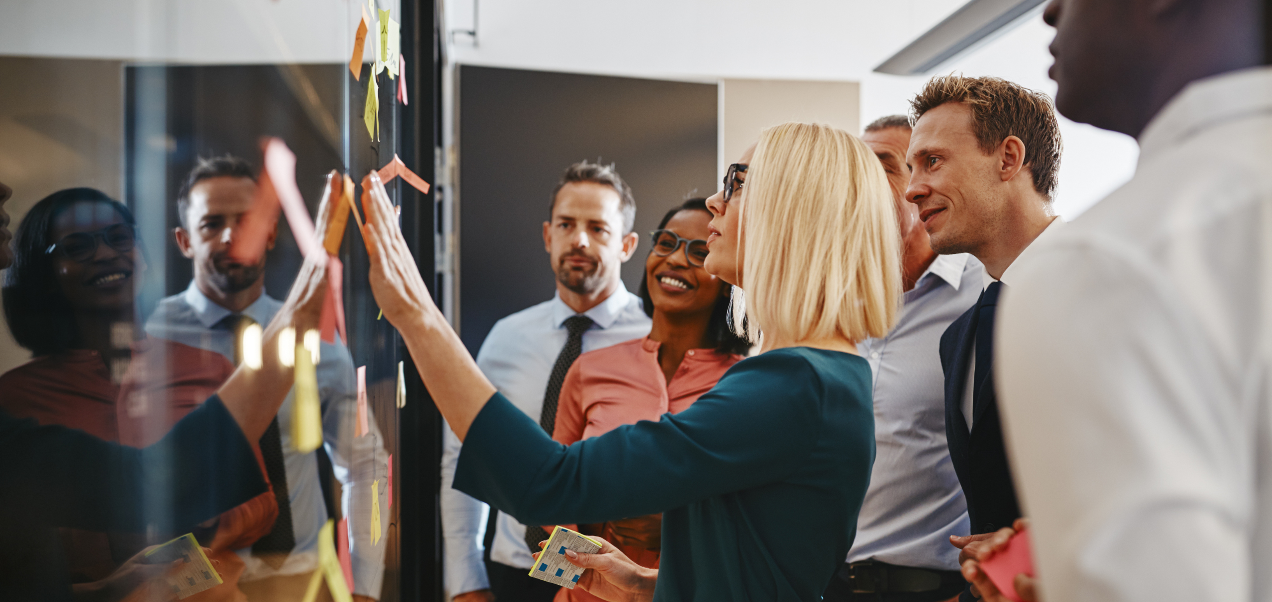 Businesswoman and Her Team Brainstorming with Sticky Notes